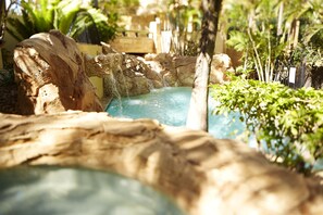 Relax by the serene pool surrounded by lush gardens and natural rock formations.