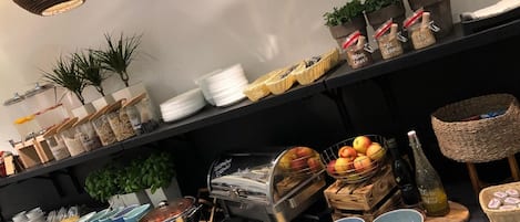 Una mesa de buffet con diversos alimentos, como frutas, quesos y salsas.