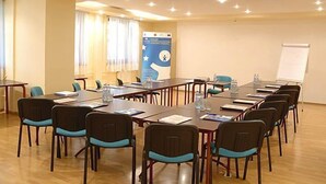 A conference room with a long table, chairs, a whiteboard, and a poster on the wall. - Parkhotel Economic (Wielka Wies)
