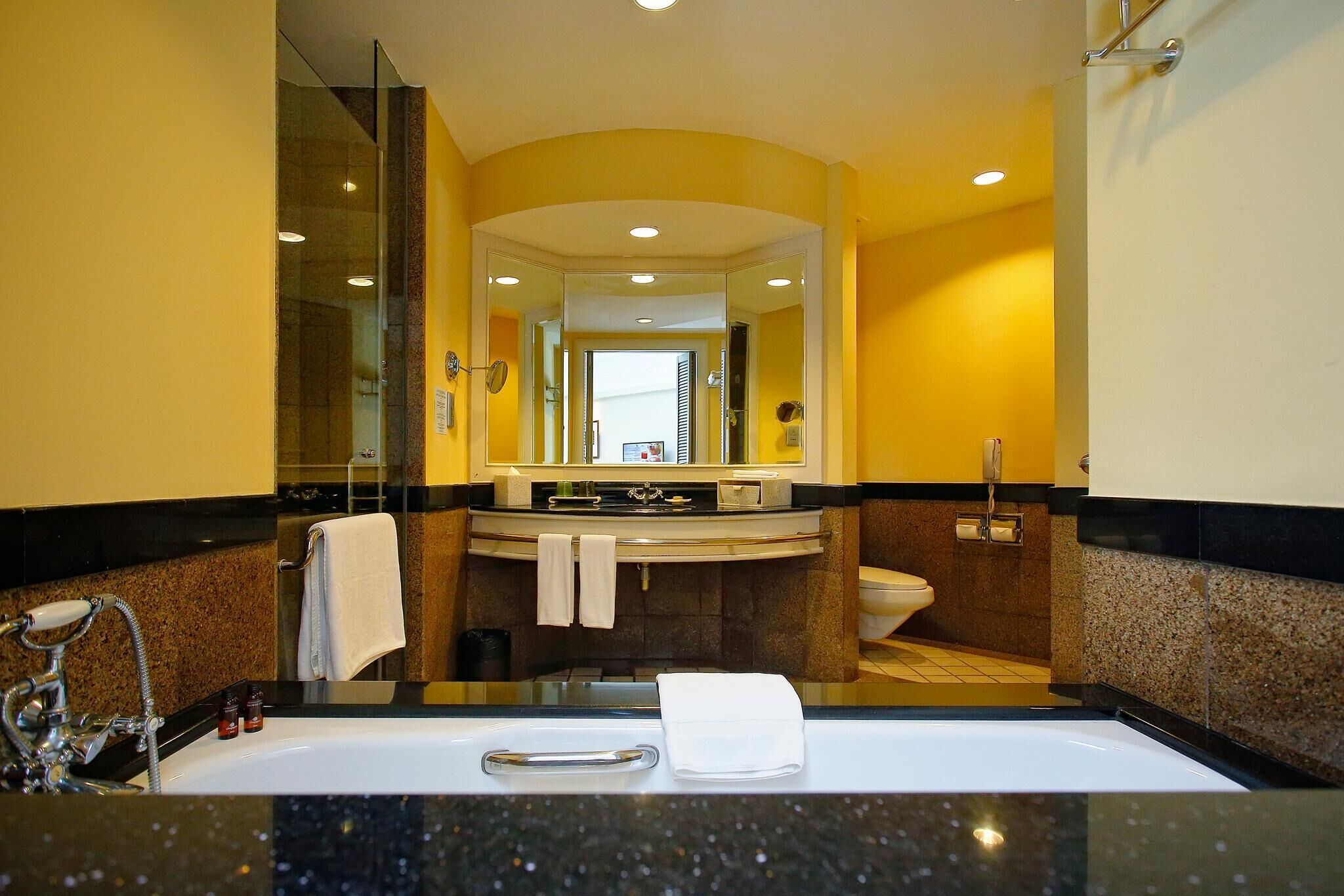 A modern bathroom with a large sink, mirror, and toilet.