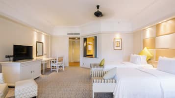 Une chambre d’hôtel comprenant un lit, un bureau, une télévision et un coin salon.