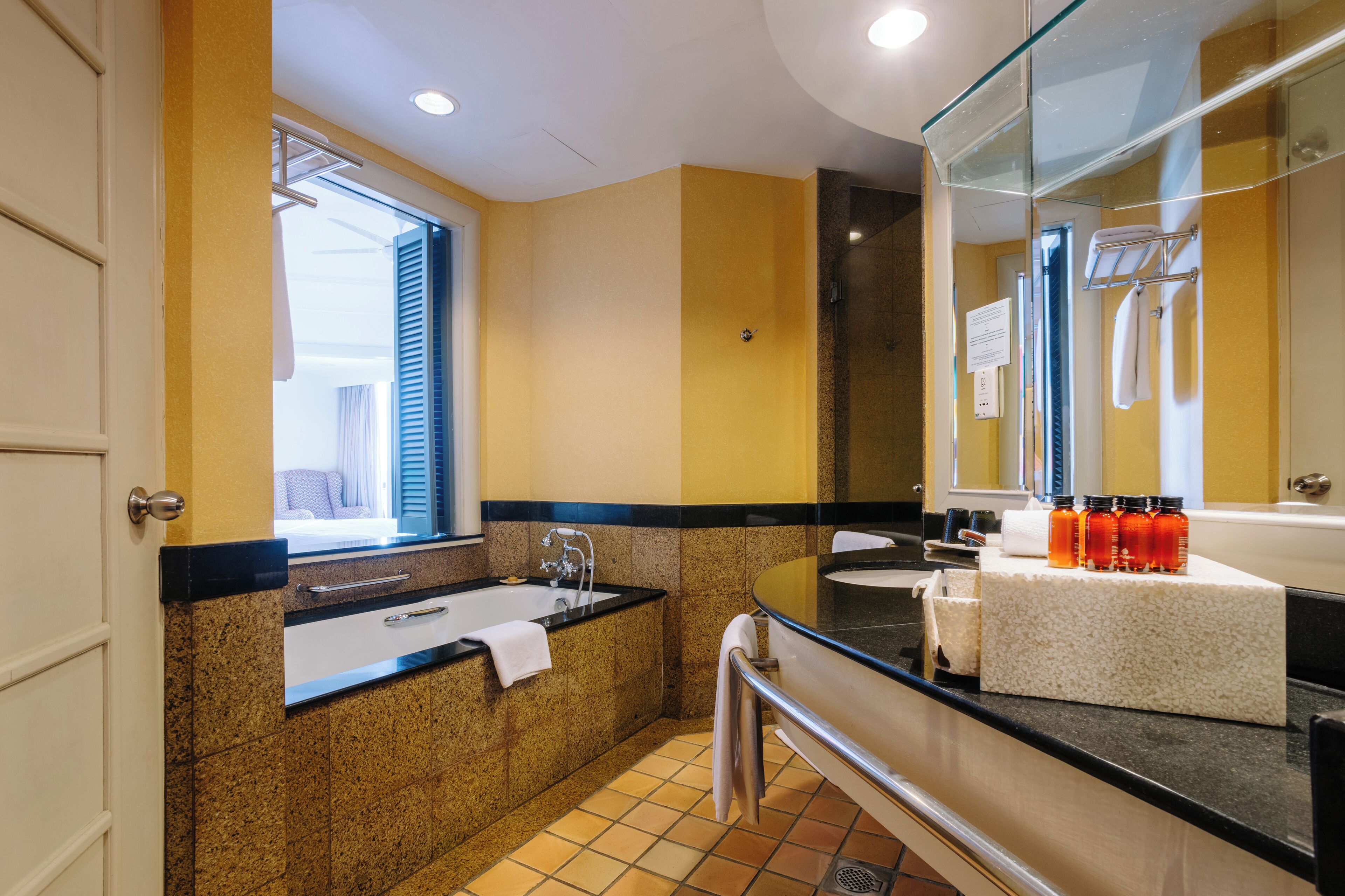 A modern bathroom with a bathtub, sink, and large mirror.
