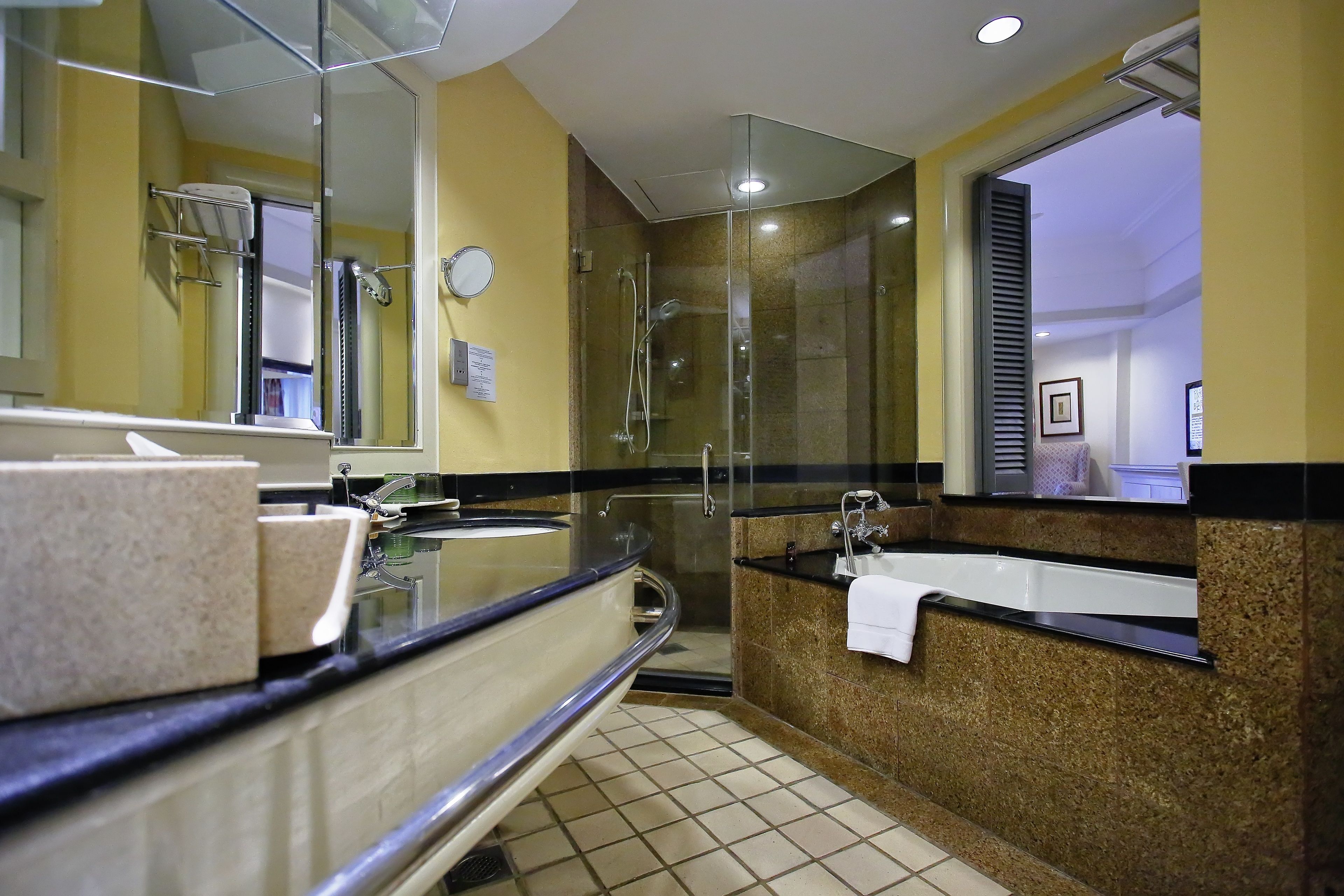 Un baño moderno con cabina de ducha de vidrio, un espejo grande y un mueble de tocador doble.
