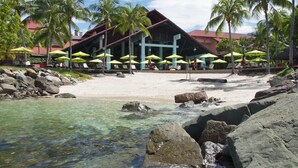 A beachfront hotel with outdoor seating and palm trees. - The Magellan Sutera Resort (Kota Kinabalu)