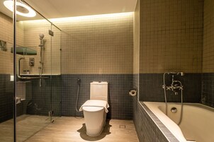 Un baño moderno con ducha de vidrio, inodoro independiente y bañera.