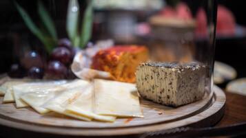 Una tabla de quesos con diferentes tipos de queso y uvas sobre una tabla de madera.