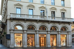A Fendi store with large glass windows and mannequins displaying clothing.