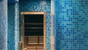 A hallway with blue mosaic tiles and a wooden bench. - Rocco Forte Hotel De Russie (Rome)
