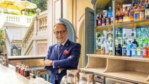 A bar area with a bartender, a variety of liquor bottles, and a bar counter with cocktail shakers. - Rocco Forte Hotel De Russie (Rome)