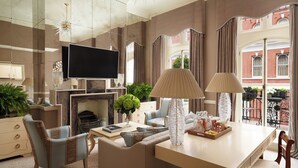 Una sala de estar moderna con chimenea, asientos cómodos, un televisor de pantalla plana y vistas a la ciudad.