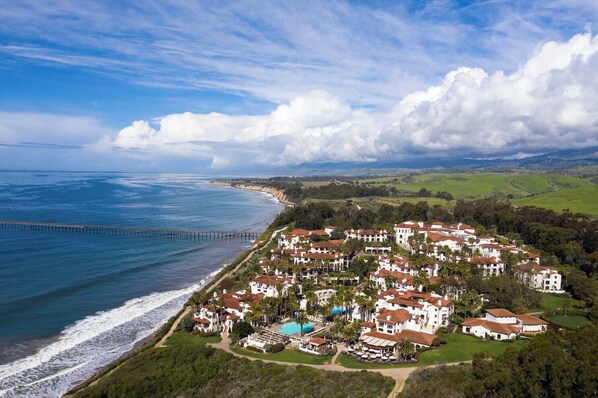 A coastal resort with villas, a beach, and a pier.