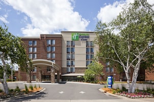Edificio de Holiday Inn Express & Suites con fachada de ladrillo, múltiples ventanas y un acceso cubierto.