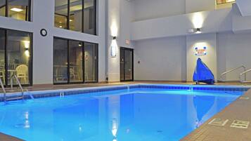 An indoor swimming pool with clear water, a lifeguard station, and a sign indicating no lifeguard on duty.