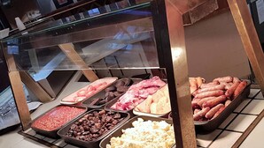 A buffet with various food items including meats, beans, and vegetables.