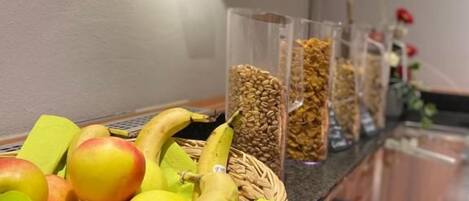 Un bufé de desayuno con frutas, nueces y cereales.