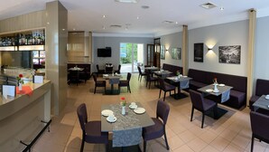 Een moderne hotelentree met een bar, eetgedeelte en zitplaatsen.
