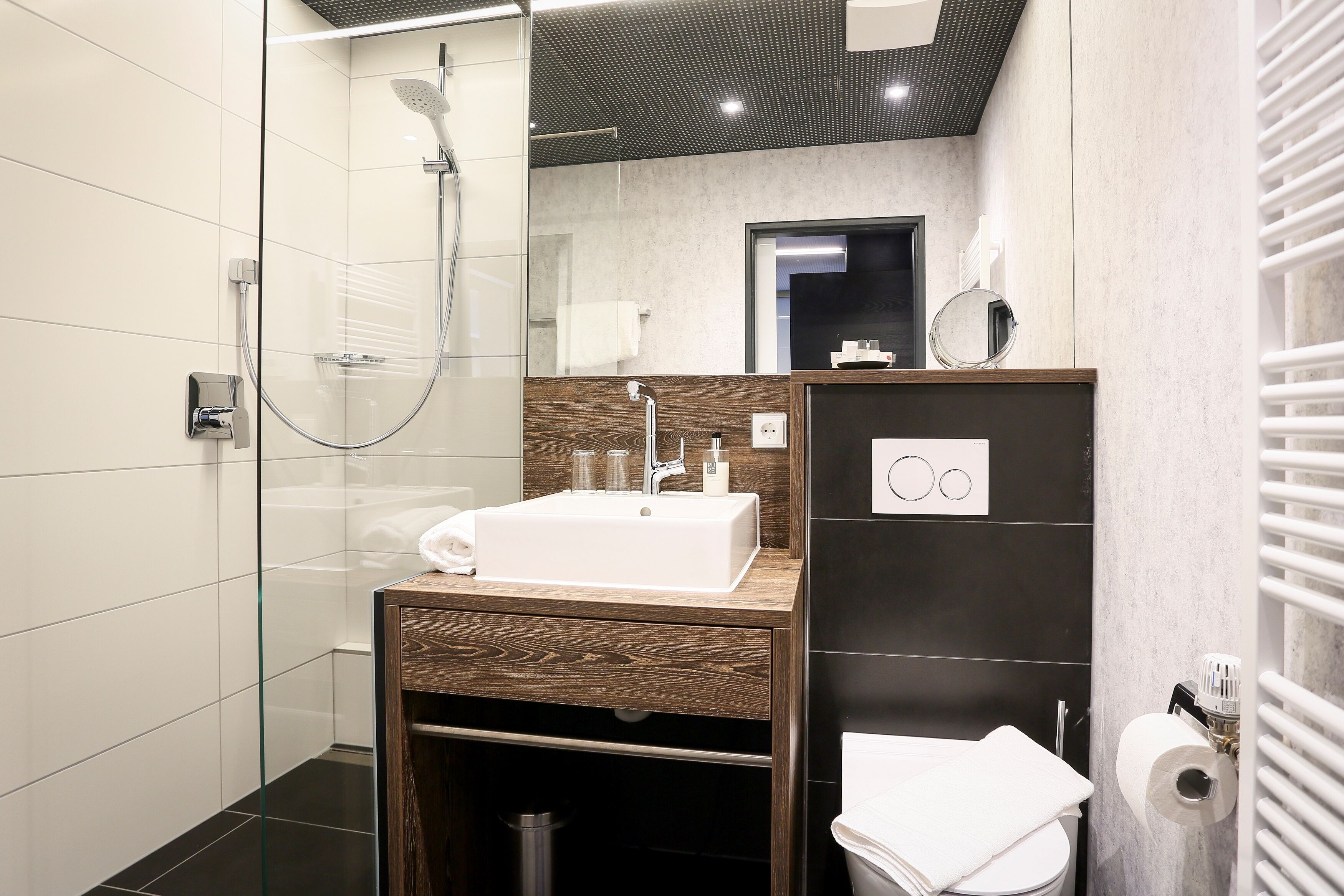 Ein modernes Badezimmer mit einer Duschkabine, einem Holzbadezimmerhocker und einer Toilette.
