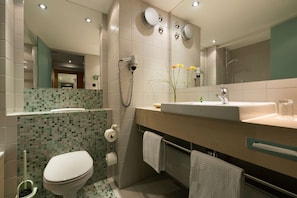 A modern bathroom with a toilet, sink, and shower. - Atlantic Hotel Universum (Bremen)