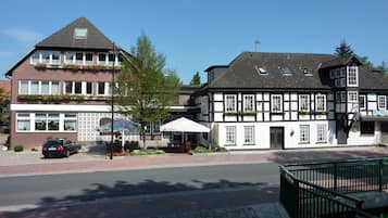 A traditional European building with a black and white facade, a car parked in front, and a cobblestone street.