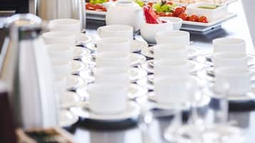 A buffet table with various food items and a coffee station.
