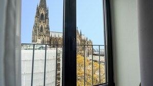 Une vue d’une cathédrale à travers une fenêtre ornée d’une rambarde en métal.