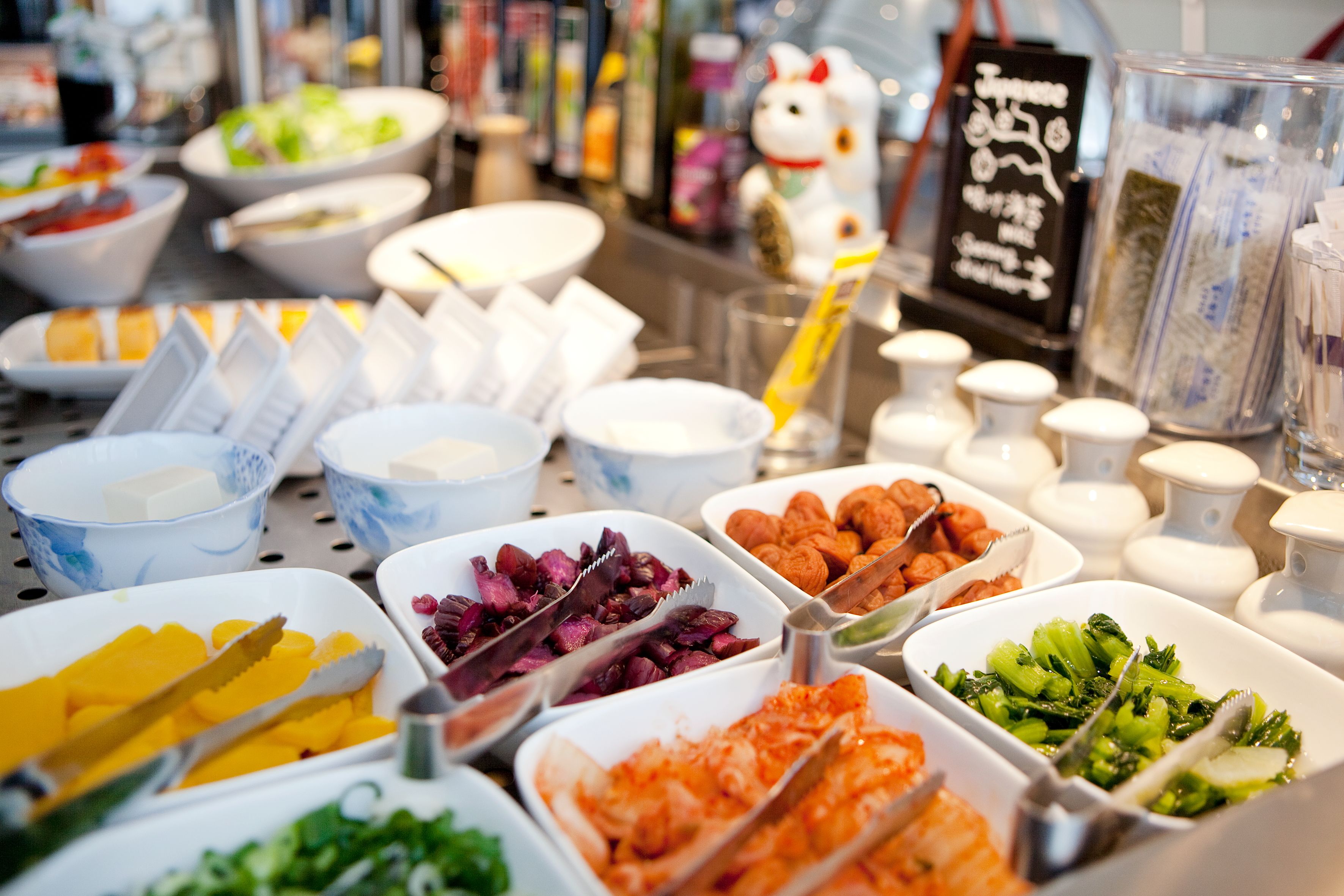 A buffet with various food items and utensils.