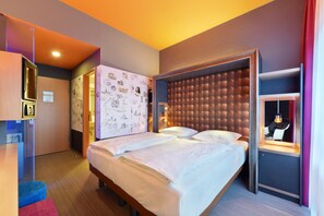 Enjoy a comfortable stay in this stylish room with a large bed, tufted headboard, wardrobe, desk, and cozy seating area.