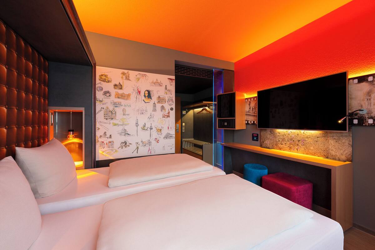 Een moderne hotelkamer met een groot bed, een zithoek met een kaart en een televisie.