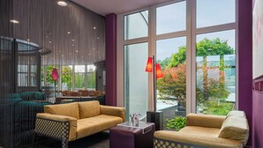 A modern interior with two sofas, a coffee table, and a decorative vase. - Designhotel Wienecke XI. Hannover (Hannover)