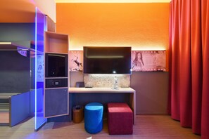 Relax in a cozy space with a flat-screen TV, desk, and seating area featuring a stool.
