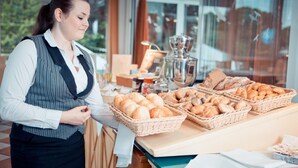 Mostrador de panadería con panes y pasteles expuestos en cestas.