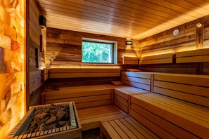 A sauna with wooden benches and a window. - Hotel Heide Kröpke (Essel)