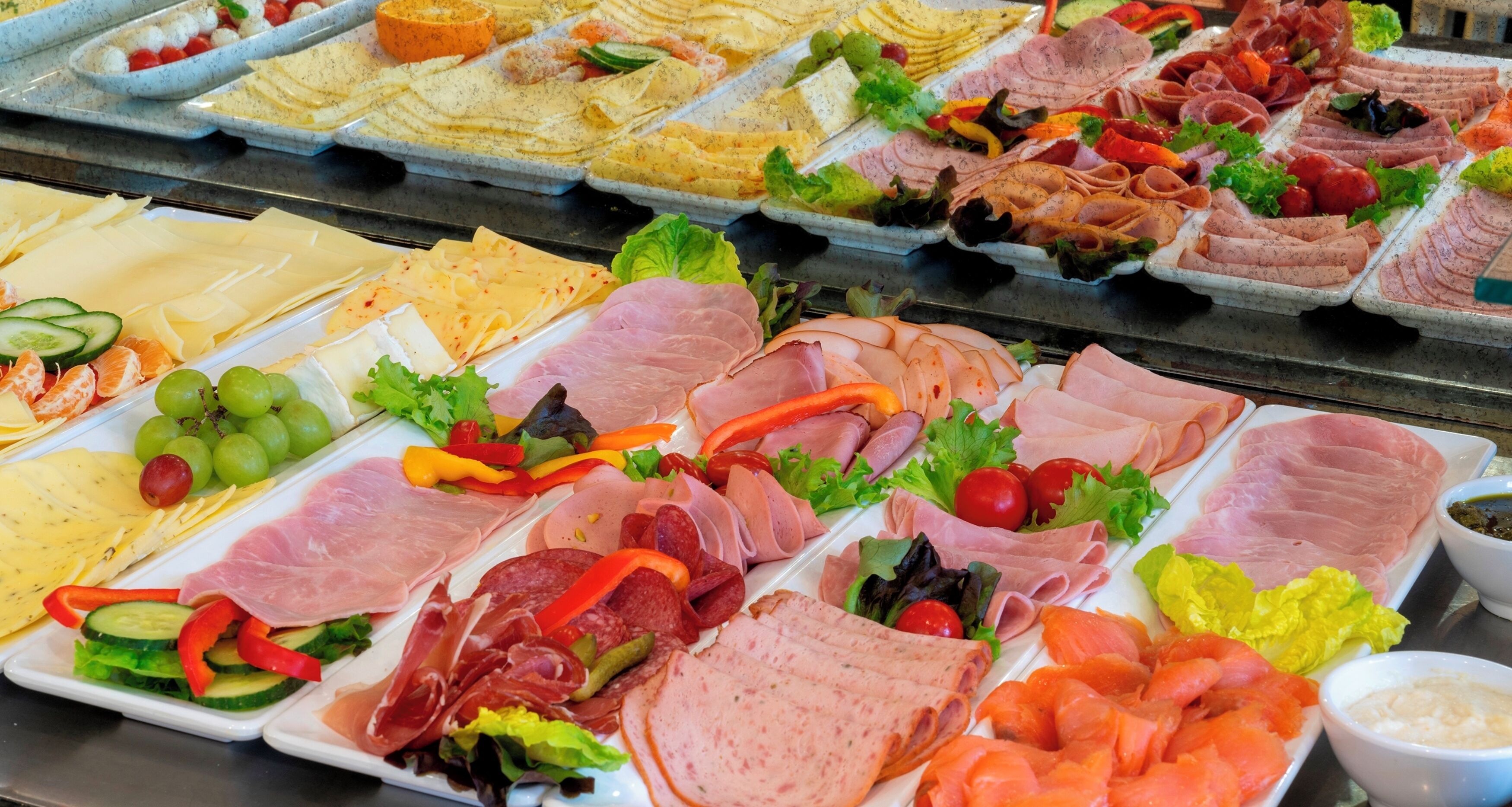 A variety of deli meats and cheeses on display.