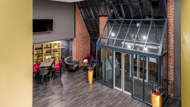 Un interior moderno con zona de comedor, chimenea y un amplio ventanal.