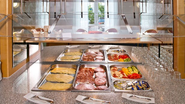 Un mostrador de buffet con distintos alimentos y utensilios.
