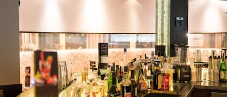 A bar area with various liquor bottles and a coffee machine.