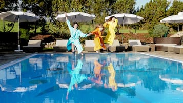 Una piscina cubierta, una piscina al aire libre, sombrillas, tumbonas