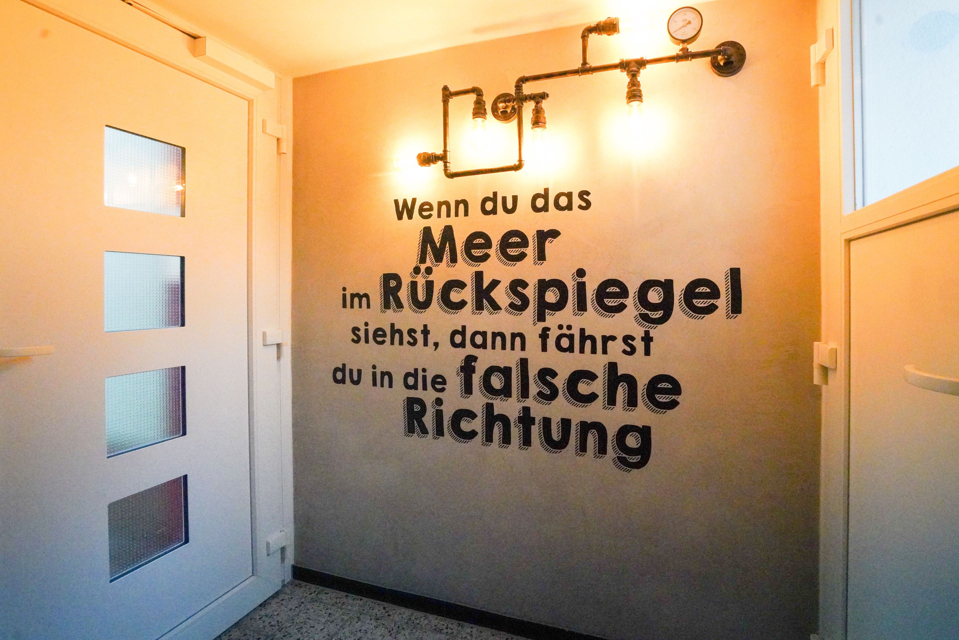 A hallway with a wall featuring a German quote about perspective.