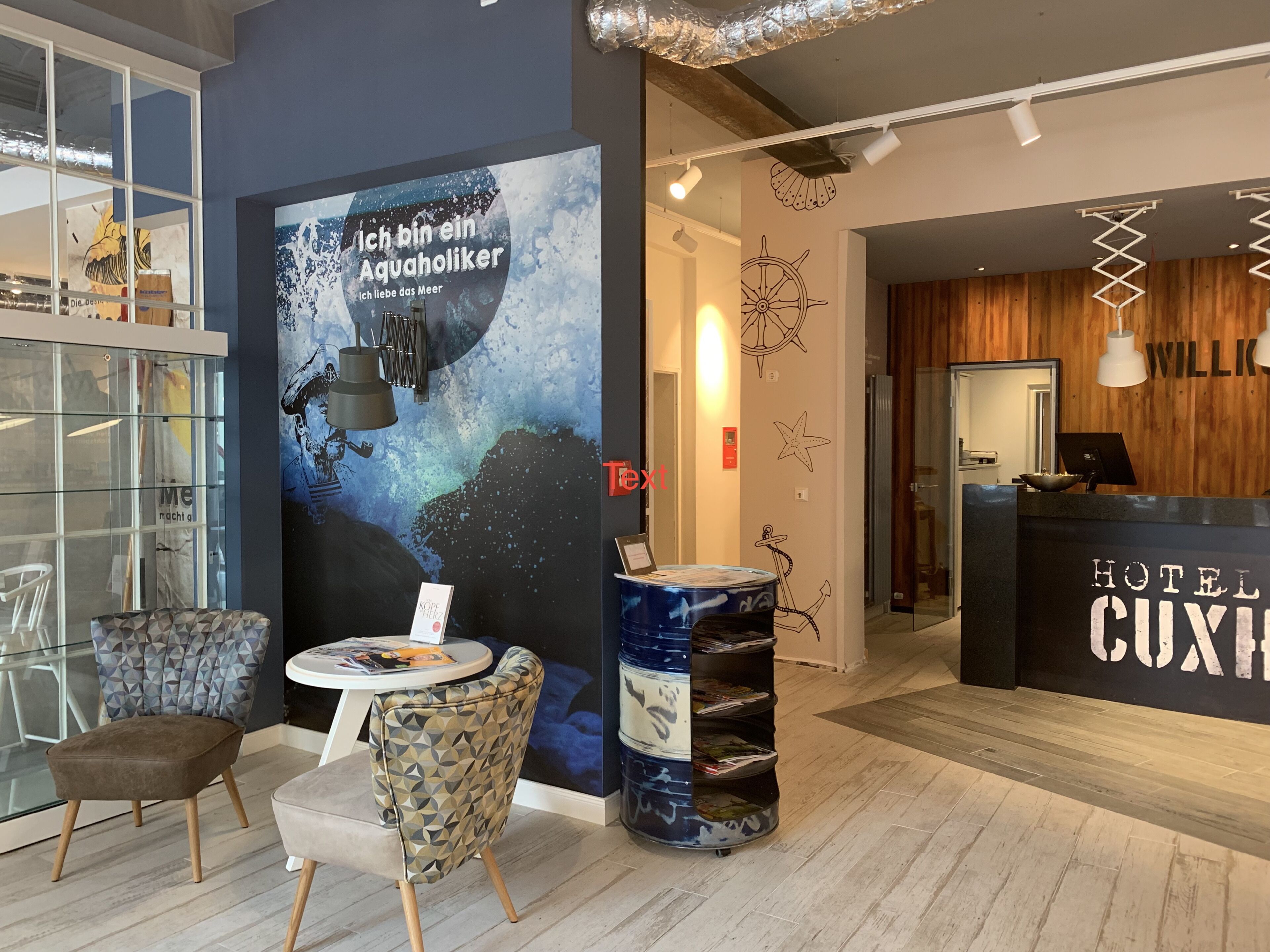 A hotel lobby with a reception desk, seating area, and a large poster.