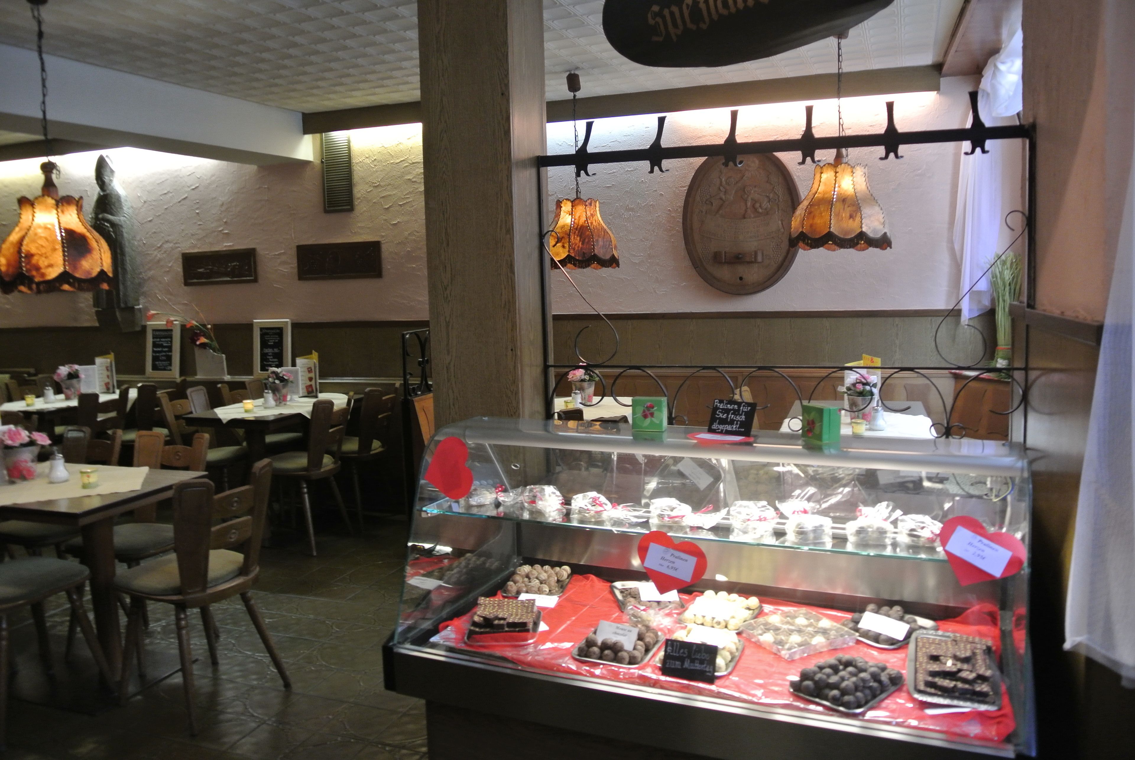 A bakery display case with various baked goods and a sign above it.