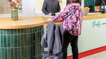 A reception desk with a green and white color scheme, a vase with flowers, and a sign that reads "Really amazing."