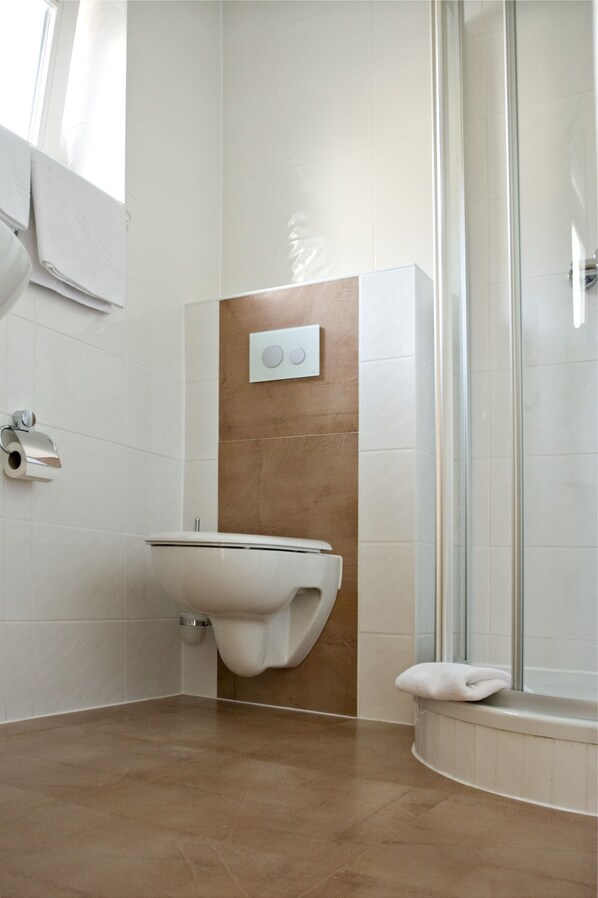Un baño moderno con lavabo, inodoro y ducha.