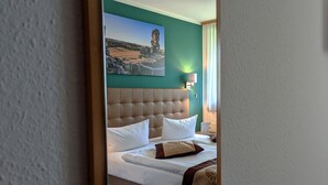 A hotel room with a large bed, a headboard, and a painting on the wall. - ACRON Hotel Quedlinburg (Quedlinburg)