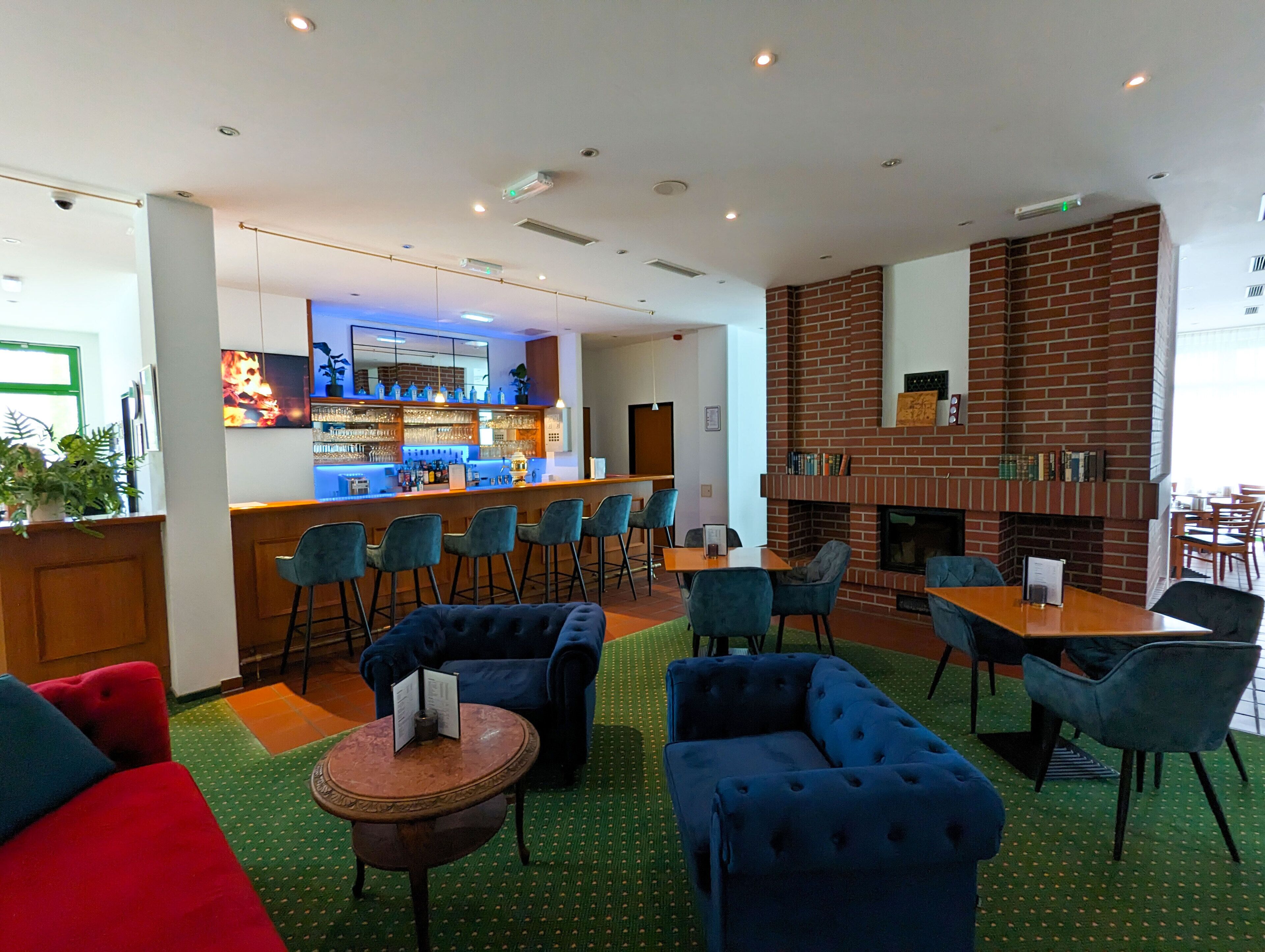 Un espace de détente moderne doté d’un bar, de sièges et d’une cheminée.
