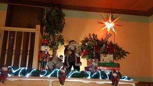 A Christmas display with a star-shaped light, a nutcracker, and a Santa Claus figure. - Hotel Zum Bürgergarten (Südharz)