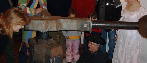 Egy csoport ember gyűlt össze egy mechanikus szerkezet körül, valószínűleg egy bemutató vagy rendezvény alkalmából.