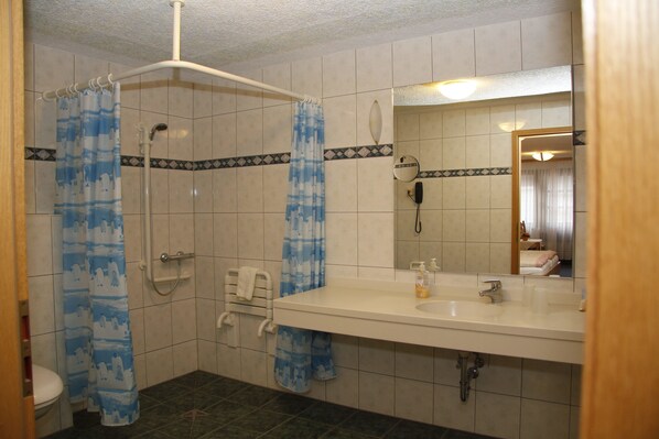 A bathroom with a shower, toilet, and sink. - Hotel Zum Bürgergarten (Südharz)