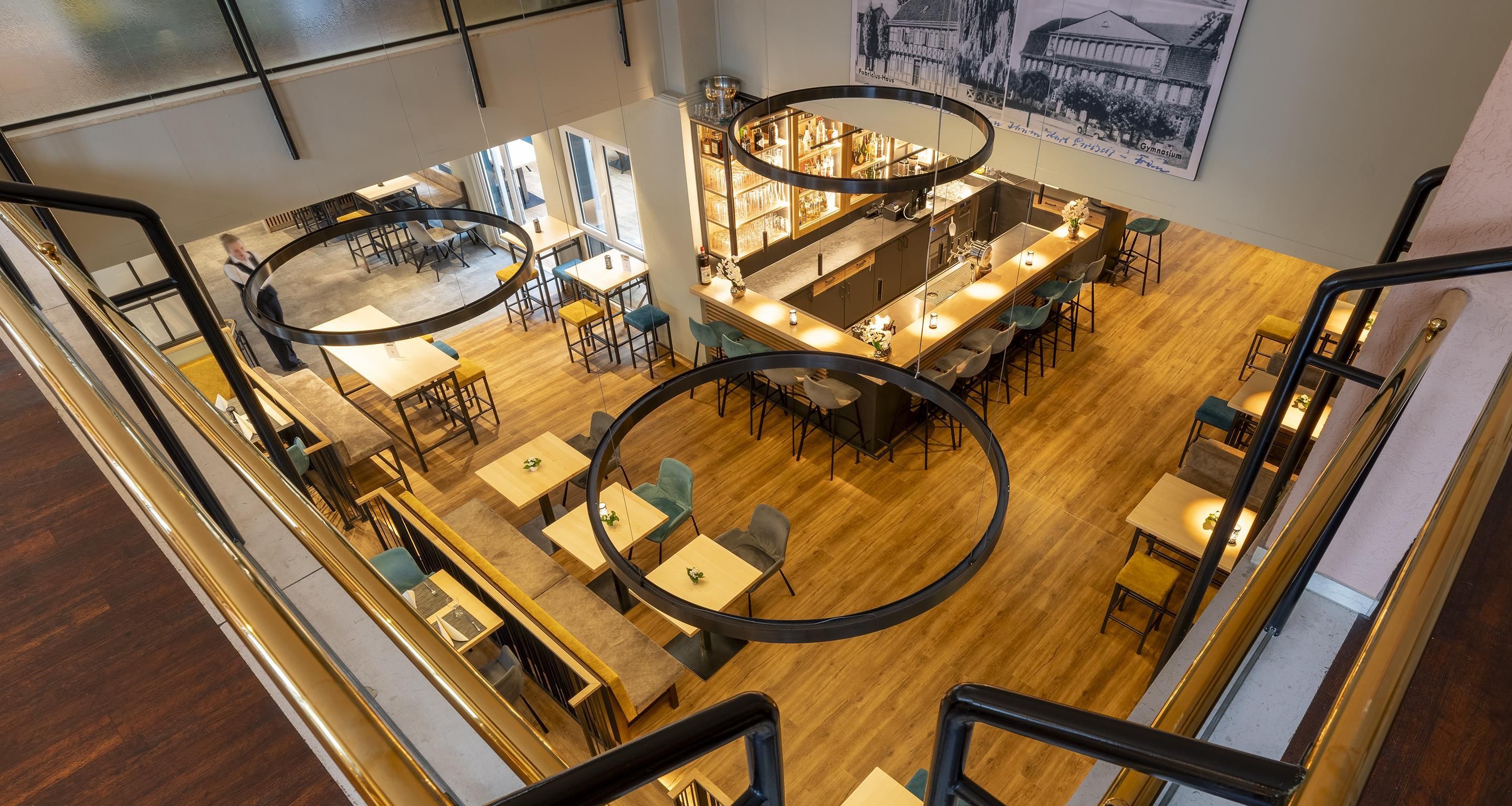 Un restaurant d'alt sostre amb diverses zones d'esbarjo, una barra i una escala.