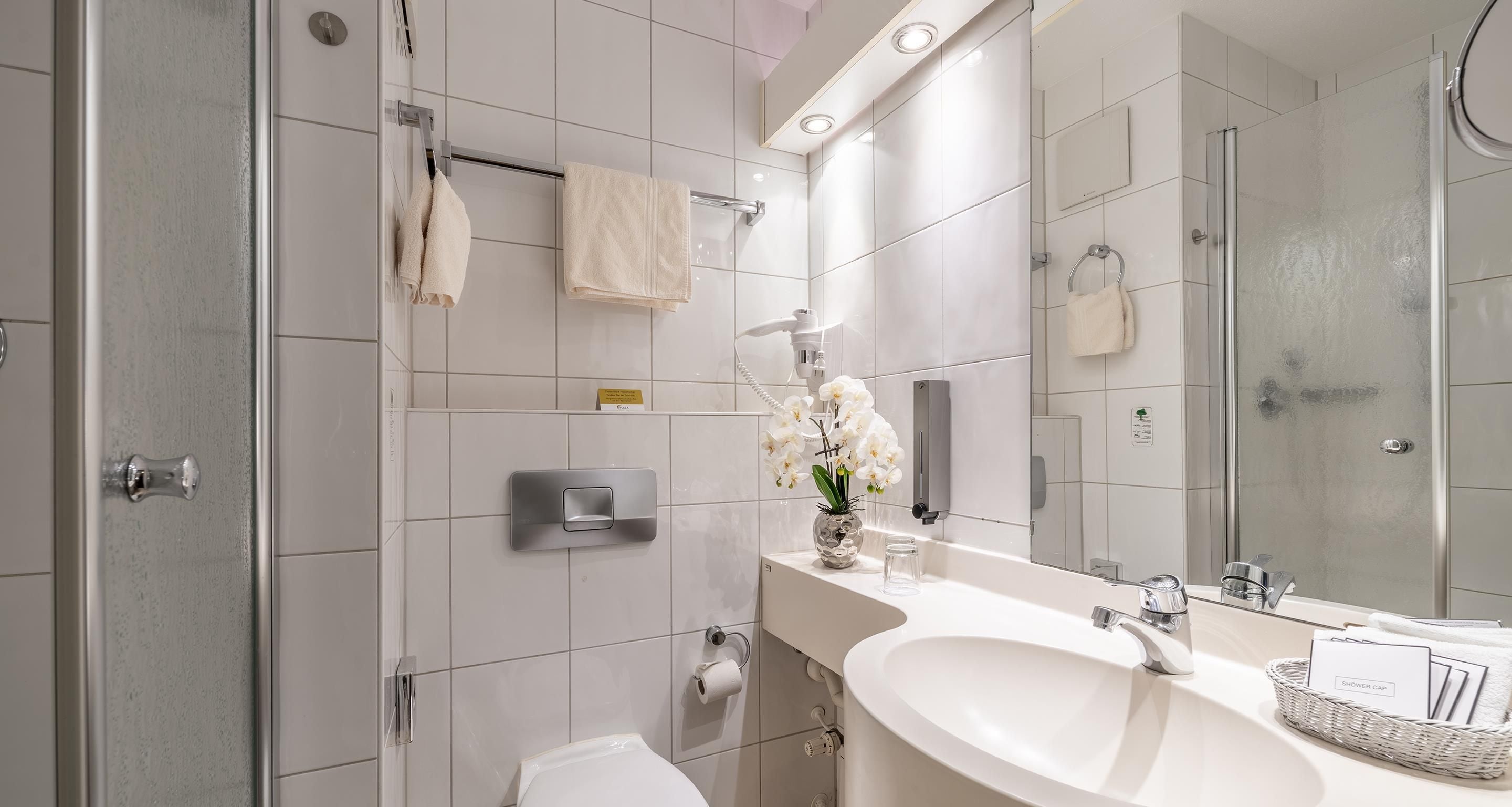 A modern bathroom with a shower, toilet, and sink.