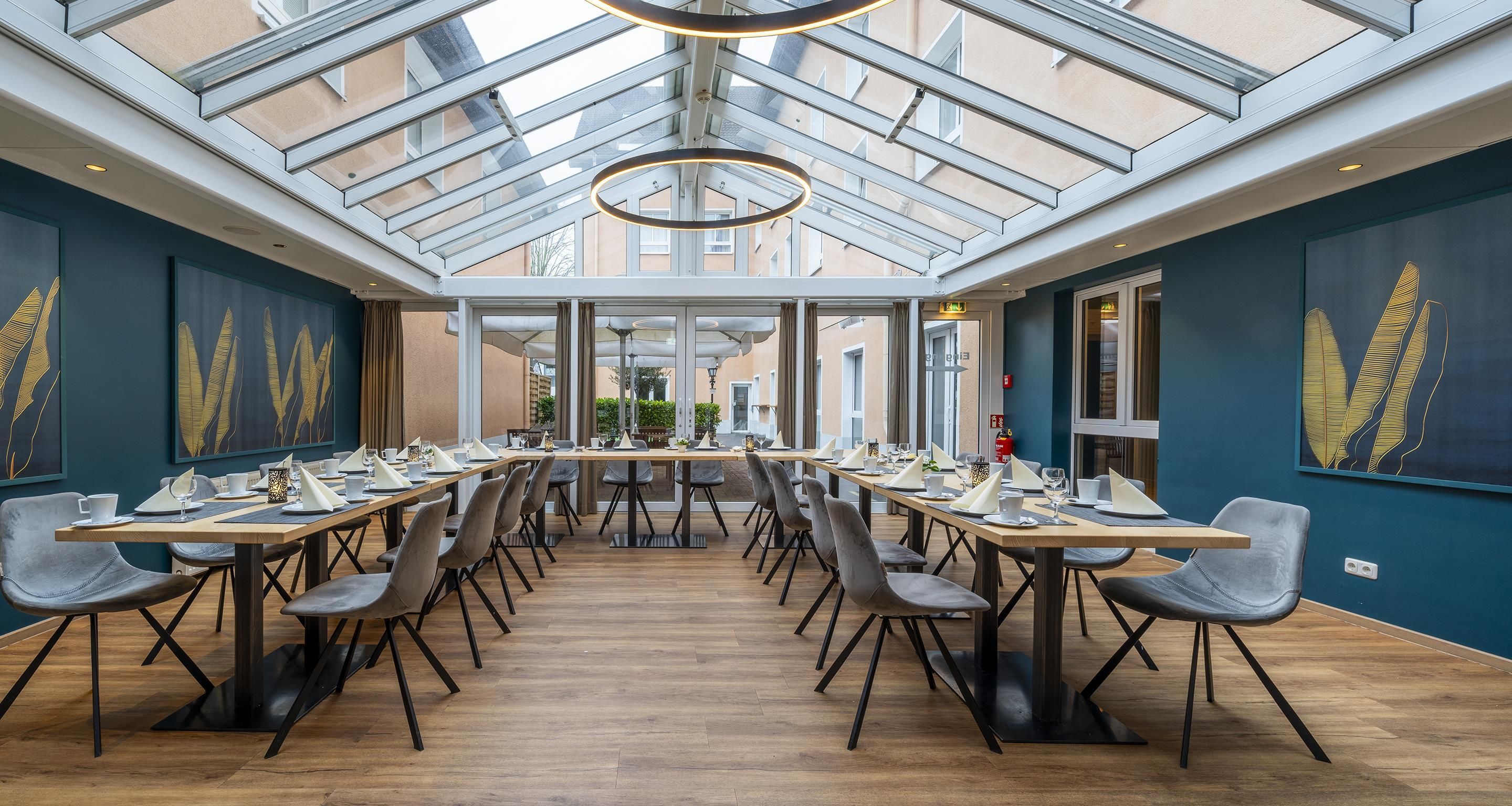 A spacious dining area with a high ceiling and skylight, featuring modern furniture and artwork on the walls.